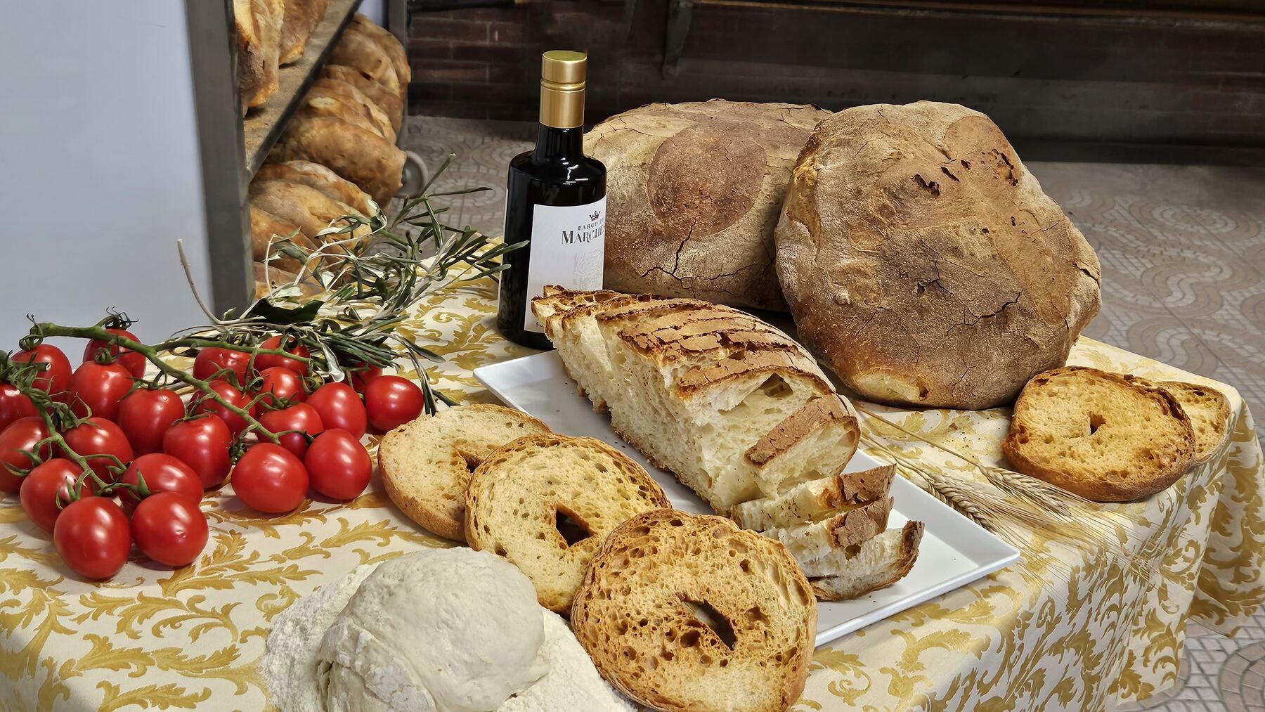 Tavola di specialità italiane: pane, olio extravergine e pomodorini
